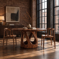 Round dining table on a pedestal of crossing curved struts in an industrial loft dining room with exposed brick