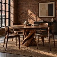 Round dining table with a twisted ribbon pedestal in an industrial loft dining room with exposed brick