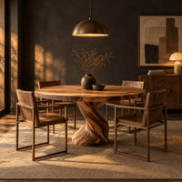 Round dining table on a twisted spiral pedestal base in a dark dining room at golden hour
