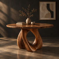 Circular dining table on a sculpted pedestal with a large open loop, three-quarter view showing the grain