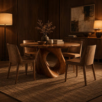 Circular dining table on a sculpted pedestal with a large open loop in an evening dining room with walnut wall paneling
