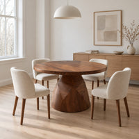 Circular dining table with a faceted bell shaped pedestal base in a Scandinavian dining room with white walls