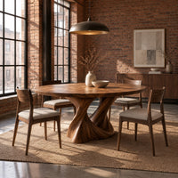 Round dining table on a twisted pedestal base in an industrial loft dining room with exposed brick