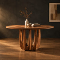 Round dining table on a pedestal made of arched wood columns in a dark studio against a charcoal plaster wall