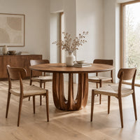 Round dining table on a pedestal made of arched wood columns in a Scandinavian dining room with white walls