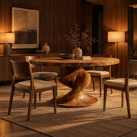 Round dining table with a spiral twist pedestal base and a wide flat foot in an evening dining room with walnut wall paneling