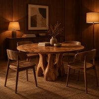 Circular dining table on branching arched pedestal legs in an evening dining room with walnut wall paneling