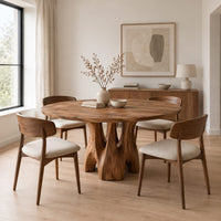 Circular dining table on branching arched pedestal legs in a Scandinavian dining room with white walls