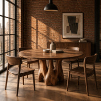 Circular dining table on branching arched pedestal legs in an industrial loft dining room with exposed brick