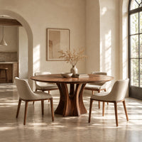 Round dining table with a flared pedestal base and a radiating grain top in a bright open plan dining room