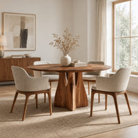 Round dining table with a flared sculpted pedestal base in a Scandinavian dining room with white walls