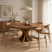Circular dining table with a swirl grain top and flared trunk shaped legs in a Scandinavian dining room with white walls
