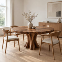 Round dining table with a thick flared pedestal base in a Scandinavian dining room with white walls