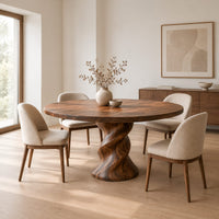 Round wooden dining table on a twisted pedestal base in a Scandinavian dining room with white walls