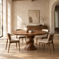 Round wooden dining table on a twisted pedestal base in a bright open plan dining room