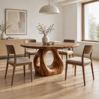 Circular wooden dining table on a sculpted pedestal with an open oval center in a Scandinavian dining room with white walls