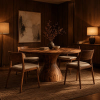 Round dining table with an hourglass pedestal base in an evening dining room with walnut wall paneling