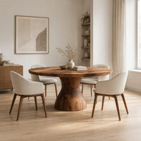 Round dining table with an hourglass pedestal base in a Scandinavian dining room with white walls