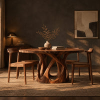 Round dining table on an open base of interlaced curves in a dark dining room at golden hour