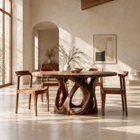 Round dining table on an open base of interlaced curves in a bright open plan dining room