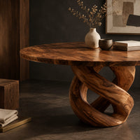 Corner detail of round dining table with a twisted loop pedestal base beside wood, brass and linen samples