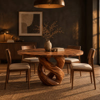 Round dining table with a twisted loop pedestal base in a dark dining room at golden hour