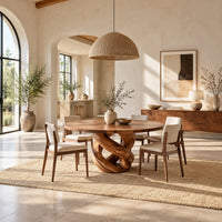 Round dining table with a twisted loop pedestal base in a bright open plan dining room