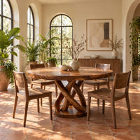 Round dining table with an interwoven wood loop base in a bright dining room with arched windows and plants