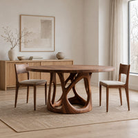 Circular dining table with an openwork branch pedestal base in a Scandinavian dining room with white walls