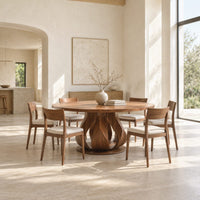Round dining table on a petal shaped pedestal with a low disc foot in a bright open plan dining room