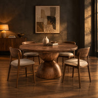 Round dining table with a radiating grain top and a sculpted hourglass base in a dark dining room at golden hour