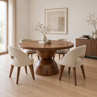 Round dining table with a radiating grain top and a sculpted hourglass base in a Scandinavian dining room with white walls