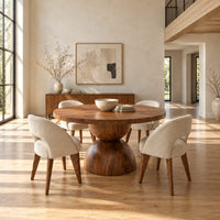 Round dining table with a radiating grain top and a sculpted hourglass base in a bright open plan dining room