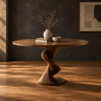 Circular dining table with a twisted pedestal base on a disc foot in a dark studio against a charcoal plaster wall