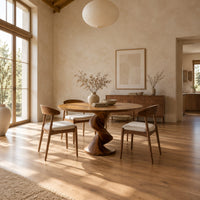 Circular dining table with a twisted pedestal base on a disc foot in a bright open plan dining room