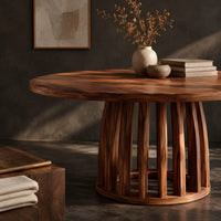 Corner detail of circular dining table with a slatted drum pedestal base beside wood, brass and linen samples