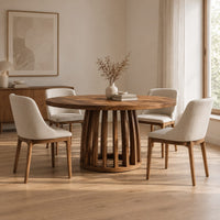 Circular dining table with a slatted drum pedestal base in a Scandinavian dining room with white walls
