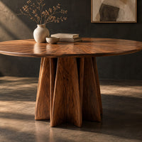Corner detail of round dining table with a sunburst grain top and a faceted star pedestal beside wood, brass and linen samples