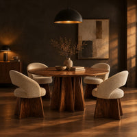 Round dining table with a sunburst grain top and a faceted star pedestal in a dark dining room at golden hour