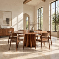 Round dining table with a sunburst grain top and a faceted star pedestal in a bright open plan dining room