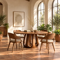 Circular dining table on a tulip shaped ring of arched legs in a bright dining room with arched windows and plants