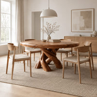 Round dining table with a twisted branch pedestal base in a Scandinavian dining room with white walls