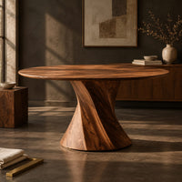 Corner detail of round dining table with a twisted hourglass pedestal beside wood, brass and linen samples
