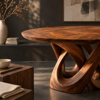 Corner detail of round dining table with a twisted loop pedestal base beside wood, brass and linen samples