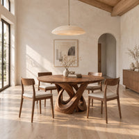 Round dining table with a twisted loop pedestal base in a bright open plan dining room