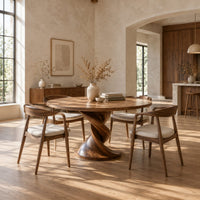 Round dining table with a twisted pedestal and disc base in a bright open plan dining room