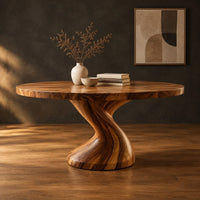 Round dining table on a single twisted pedestal in a dark studio against a charcoal plaster wall