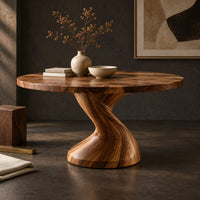 Corner detail of round dining table on a single twisted pedestal beside wood, brass and linen samples