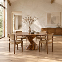 Round dining table on a single twisted pedestal in a bright open plan dining room