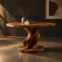 Round dining table with a spiral twisted pedestal on a thick disc base, three-quarter view showing the grain